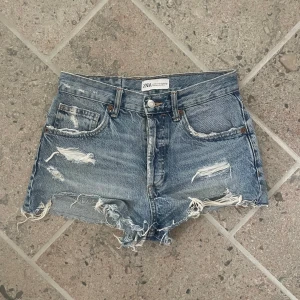 Blå slitna jeansshorts från Zara - Snygga jeansshorts med slitningar. Använda några gånger, midjemått 35cm💗