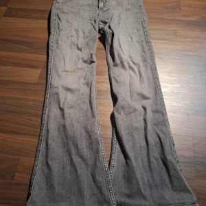 Grå bootcut jeans från Lee - Snygga grå jeans från Lee med bootcut passform. Klassisk femficksmodell med Lee-logga på knappen och bakfickan. Jeansen har en cool tvättad look och är tillverkade i mjukt denimtyg som sitter skönt hela dagen.