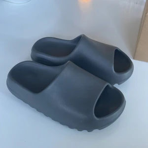Adidas Yeezy Slide granit - De är knappt använda och ser helt nya ut inga täcken på användning. De är små i storleken.