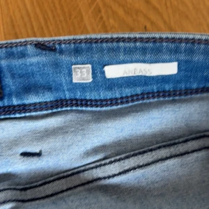 Replay Anbass jeans blå W33 L34 - Är vilig att förhandla om priset så skriv vid intresse Säljer ett par Replay Anbass jeans i klassisk blå tvätt med snygga slitningar. Modellen har fem fickor, dragkedjegylf och tydliga Replay-detaljer vid fickan. Jeansen är tillverkade i bomull och har en modern passform som funkar till det mesta.