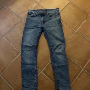 Blå skinny jeans från Nudie - Nudie Jeans Lean Dean – ljusblå, stl 30/30 Snygga och bekväma jeans i modellen Lean Dean från Nudie. Ljusblå tvätt, storlek 30/30 – passar dig som är ca 173–180 cm beroende på kroppstyp. Använda men i fint skick. Skicka DM för fler bilder eller frågor! OBS priset kan sänkas vid snabb affär.