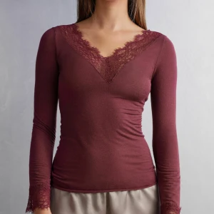 Vinröd spetsdetaljerad topp Intimissimi - Supersnygg vinröd långärmad topp från Intimissimi med v-ringning och spetsdetaljer vid halsringning och ärmslut. Tröjan är endast använd en gång och är i super bra skick! 
