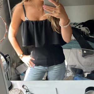 Svart volang topp från Zara - Supersnygg svart topp från Zara med volang över bysten och utan band (mina bh-band som synd). Sitter figurnära och kan användas året om! Klicka gärna på ”köp nu”!