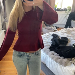 Vinröd peplumtröja med utsvängda ärmar - Säljer en aldrig använd vinröd långärmad tröja med peplumskärning och utsvängda ärmar. Tröjan har rund halsringning och är i ett mjukt, stretchigt material som sitter snyggt på kroppen. Perfekt för dig som gillar en feminin och trendig look.