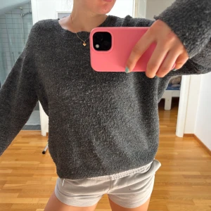 Mörkgrå stickad tröja från H&M - Mysig mörkgrå stickad tröja från H&M i storlek S. Tröjan har en klassisk rund halsringning, långärmade ärmar och en loose passform. Perfekt för lager-på-lager och chill dagar. Materialet är mjukt och ger en avslappnad vibe.
