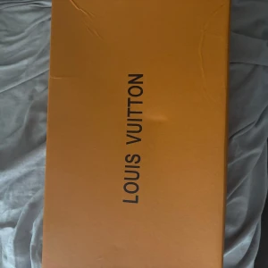 Svarta sneakers från Louis Vuitton pris kan diskuteras  - Snygga svarta sneakers från Louis Vuitton med stickad ovandel och diskret rutmönster. Skorna har snörning och en chunky sula som ger en modern vibe. Perfekta för dig som vill ha en exklusiv touch på din streetstyle.