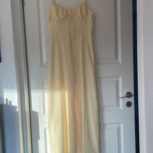 Gul lång milkmaid klänning  - Gul lång klänning från shein i storlek small. Når precis ner till golvet på mig som är 153 cm. Andra bilden visar färgen bäst, smörgul typ. 100kr
