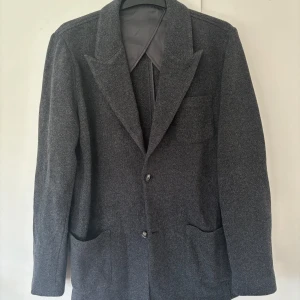 John Henric kavajjacka - Snygg elegant populär mörkgrå kavajjacka från John Henric i storlek M (axelbredd på 48 cm) säljes. Perfekt att använda som cardigan för dig som är stilmedveten. Toppen skick som ny. Tveka inte vid minsta fråga eller fundering och pris ej hugget i sten😃