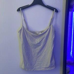 Vit linnetopp från Gina Tricot S - Enkel och stilren vit linnetopp från Gina Tricot, kollektionen Basically Basics. Tunt och mjukt material med smala, justerbara axelband. Perfekt att matcha med jeans eller kjol för en clean look.
