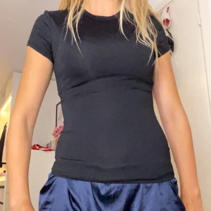 Svart tight t-shirt XS - Enkel och stilren svart t-shirt i tight passform. Klassisk rund halsringning och korta ärmar. Perfekt basplagg som funkar till allt och är lätt att matcha. Mjuk och stretchig.