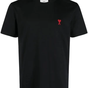 Svart t-shirt från Ami med rött hjärta - Svart t-shirt från Ami med klassisk passform och korta ärmar. På bröstet finns en liten röd broderad logga i form av ett hjärta med bokstaven A. Tillverkad i mjuk bomull, perfekt för en clean och stilren look.