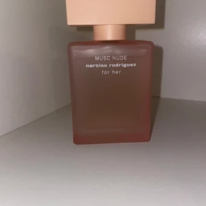 Musc Nude parfym från Narciso Rodriguez - Musc Nude från Narciso Rodriguez for her är en elegant parfym i en matt, fyrkantig glasflaska med nude-rosa ton och matchande lock. Flaskan har en stilren och modern design som känns lyxig och trendig.