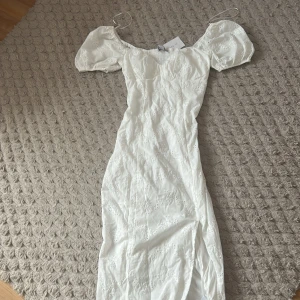 Vit långklänning med puffärm från Aware - Superfin vit långklänning med broderade blommor och puffärmar Perfekt för sommarens alla tillfällen! Materialet är bomull och ger en luftig känsla. Aldrig använt tidigare då den aldrig kommit till användning🪽Hör av er för fler bilder eller frågor 🩷 Pris går att diskutera!