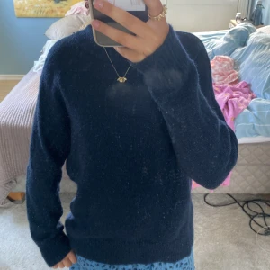 Mörkblå stickad tröja från H&M XS - Mysig mörkblå stickad tröja med lite glitter i från H&M i storlek XS. Tröjan har rund halsringning, långa ärmar och är tillverkad i en blandning av mohair, ull, akryl och polyester. Perfekt för kyliga dagar och enkel att matcha med jeans eller kjol.