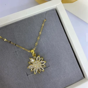 Guldigt halsband med blomma och stenar - Superfint halsband i guldton med ett hängsmycke format som en blomma. Blomman är dekorerad med gnistrande vita stenar i både mitten och kronbladen, vilket ger ett lyxigt och glittrigt intryck. Ej använd utan kommer från min small business. 