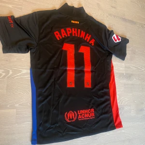 FC Barcelona Raphinha Nike fotbollströja - •Säljer en jätte fin 24-25 svart Barca T-shirt med Laliga patches och Raphina på ryggen.  •Den är inte använd bara testad, jätte bra skick och inga fläckar eller hål.  •Och det är storlek M och måtten finns på dem sista bilderna •Priset kan diskuteras och skickar inom 24 Tim 💨😊