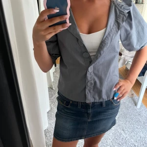 Grå overshirt med puffärm och stora knappar - Säljer en grå overshirt med bred krage och puffiga trekvartsärmar. Jackan har stora dekorativa knappar framtill.