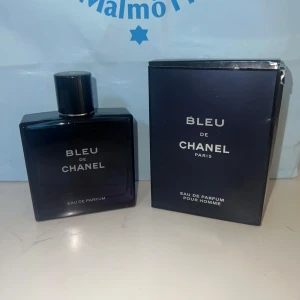 Bleu de Chanel Eau de Parfum 100ml - Bleu de Chanel Eau de Parfum för herr, 100 ml. Flaskan är mörkblå och fyrkantig med minimalistisk design och svart lock. Kommer med originalkartong i matchande mörkblå färg. En ikonisk och fräsch doft från Chanel som utstrålar stil och elegans.