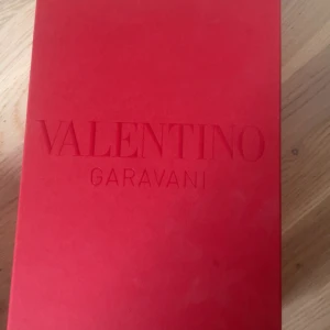 Valentino Garavani Open sneakers svart/vit - Snygga Valentino Garavani Open sneakers i vitt skinn med bred svart rem över vristen. Klassisk och stilren design med rund tå och platt sula. Kommer med originalkartong och tillbehör. Perfekta för dig som gillar exklusiva och trendiga sneakers. Köpta i valentinos butik i Italien. Har används typ 7 gånger. Köptes för 7500, pris kan diskuteras! 