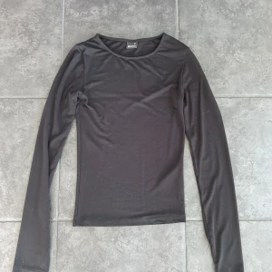 Svart långärmad topp Gina Tricot - Enkel och stilren svart långärmad topp från Gina Tricot. Modellen är figurnära med rund halsringning och tillverkad i mjuk bomullsmix. Använd ett fåtal gånger.