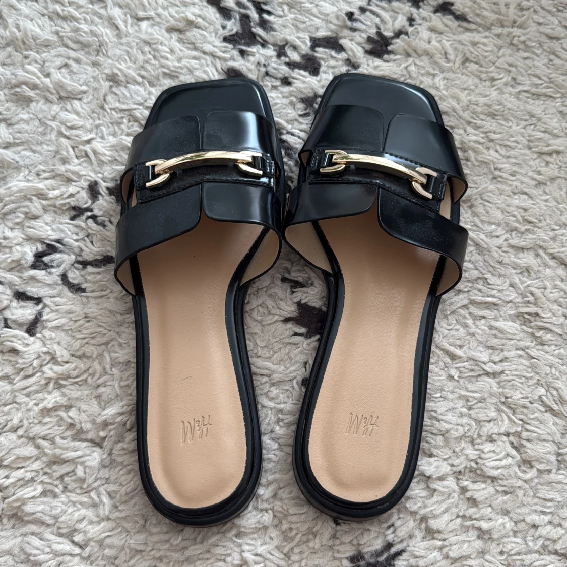 Svarta sandaler/slip-ins med gulddetalj från HM