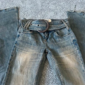 BDG Lågmidjade Bootcut Jeans - Supersnygga och unika bootcut jeans köpta ifrån Urban Outfitters. Det finns ett tillhörande skärp som går att ta bort om man vill :) Använda få gånger men finns lite slitningar💗💗 Storlek:  24W   32L