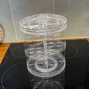 Roterande sminkförvaring  - Snygg och praktisk roterande sminkförvaring i transparent akrylplast. Perfekt för att organisera borstar, läppstift, mascaror och andra sminkprodukter. Flera fack och hyllor gör det enkelt att hålla ordning på allt ditt smink på ett stilrent sätt.