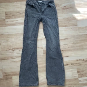 Grå bootcut jeans från Perfect Jeans - Snygga grå jeans från Perfect Jeans i bootcut-modell. Jeansen har klassisk femficksdesign och raka ben som blir vidare nertill. Perfekt för dig som gillar en retrovibe och vill ha ett par bekväma jeans med lite extra attityd.