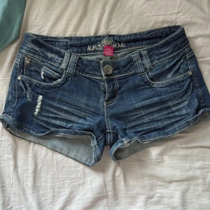 lågmidjade jeansshorts  - Snygga lågmidjade jeansshorts från Almost Famous med slitna detaljer, klassisk femficksmodell med jättesnygga bakfickor! säljer pga att de var för stora för mig