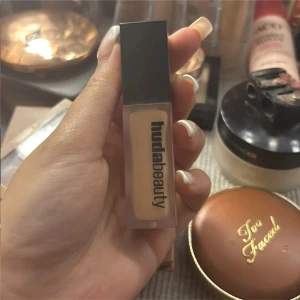 Huda Beauty concealer i beige nyans - Concealer från Huda Beauty i en snygg frostad fyrkantig tub med svart lock. Färgen är en ljus beige ton som passar perfekt för att ljusa upp under ögonen eller täcka blemmor. Enkel att applicera med sin smidiga applikator. Som ny Originalförpackning finns kvar 🧾 Kvitto finns vid förfrågan 💬 Skriv om du vill ha fler bilder eller nyanser! 