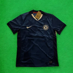 Chelsea Palmer 10 matchtröja Nike - Chelsea FC matchtröja med Palmer 10-tryck. Djupblå färg med ljusa detaljer och klubbmärke på bröstet. Tillverkad i lätt och ventilerande polyester, perfekt för fotboll eller att bära som supporter. Klassisk V-ringning och korta ärmar.