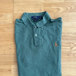 Grön pikétröja från Polo Ralph Lauren - Klassisk grön pikétröja från Polo Ralph Lauren. Classic fit-modell i mjuk bomull, perfekt för en chill och stilren look. Sitter som M/L.