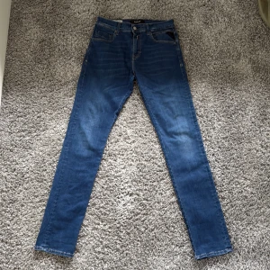 Blå Replay jeans, midwaist, w30 L32 - Säljer ett par klassiska blå jeans från Replay i modellen w30 L32. Jeansen har raka ben, och snygga detaljer på  med en skön passform som sitter snyggt på kroppen.