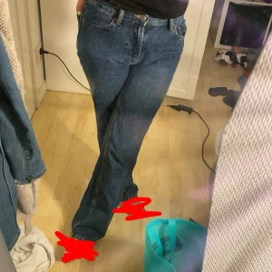 Blå raka jeans med hög midja från Gina Tricot - Säljer ett par klassiska blå jeans med hög midja och raka ben. Jeansen har fem fickor, bälteshällor och stängs med knapp och dragkedja. Perfekta för dig som gillar en tidlös och avslappnad look.