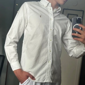 Vit skjorta från Ralph Lauren - • Nu säljs en vit Ralph lauren skjorta i mycket bra skick 👔 • Storleken är 16 år och han på bilden är ca 177cm 📏 • Mycket snygg och fräsch skjorta nu till sommaren ⭐️ • Skjortan tecken på fläckar men syns ej vid användning, endast om du tar upp plagget mot solen 🌞 • Nypris på denna är ca 1600kr men säljs för ett ofattbart bra pris på snåla 299kr ! 🤑 • Hör av dig vid minsta lilla fundering 🤔💭 • Kolla gärna in profilen för andra schyssta plagg som raffe skjortor, lanvins, replay jeans, Jacob cohen 