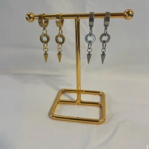 Chunky örhängen med kedjor och spikes - Säljer två par chunky örhängen i cool design, ett par i guld och ett i silver. Båda har ringar och kedjor med hängande konformade spikes. Perfekta för dig som vill sticka ut med en edgy vibe. Passar både tjejer och killar som gillar statement-smycken.