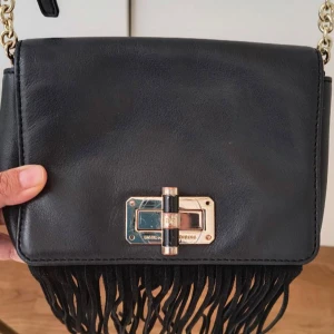 Svart axelväska med fransar från DVF - Snygg svart axelväska från Diane von Furstenberg i skinn med guldfärgade detaljer och kedja. Nypris 2500 💕