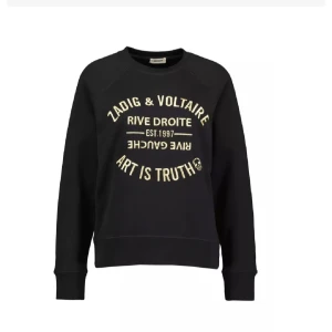 Svart sweatshirt Zadig & Voltaire - Cool svart sweatshirt från Zadig & Voltaire med tryck i guld på bröstet. Tröjan har rund halsringning och långa ärmar, perfekt för en avslappnad och trendig look. Mjuk bomullskänsla och ribbade muddar vid ärmslut och nederkant.