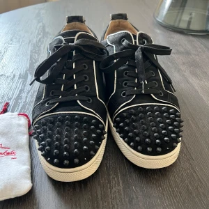 Christian Louboutin svarta sneakers med nitar - Svarta sneakers från Christian Louboutin i mocka med vita/reflex stripes. Sällsynt model, saknas 5 taggar och lådan annars är extra snören med men ingen extra taggar. Snabb affär är möjligt;)
