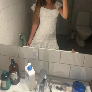 Vit spetsklänning med volang - Köpte klänningen här på plick men den passade inte mig. Den är använd en gång av förra säljaren. Klänningen har en volang där uppe som inte syns i första bilden men syns i dem andra. PRISET KAN DISKUTERAS!