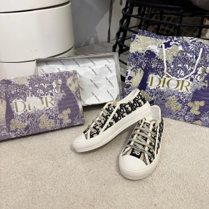 Dior Oblique sneakers i svart och vitt - Snygga Dior Oblique sneakers med svart och vitt monogrammönster, vita snören och robust vit sula med stjärndetalj undertill. Klassisk rund tå och tydlig Christian Dior-logga på sidan och tungan. Ovandel i canvas och detaljer i skinn.