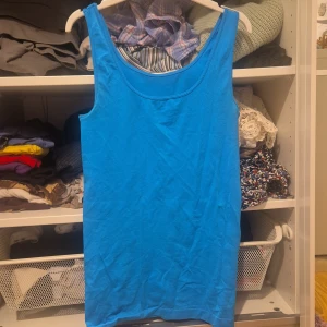 Blå linnetopp i bomull - En enkel och fräsch blå linnetopp med rund halsringning. Toppen är ärmlös och har en rak passform, perfekt för varma dagar. Tillverkad i mjuk bomull som känns skön mot huden, (tror jag, den är väldogt stretching). Snygg att styla med jeans eller shorts. Sportyyy, pris kan diskuteras♡♡