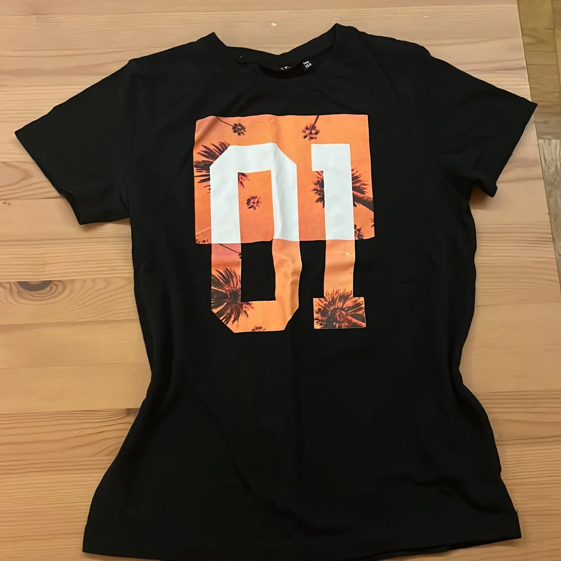 Svart t-shirt med orange print REACTION