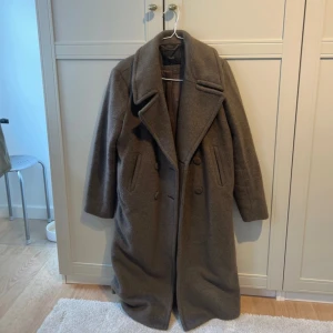 Brun ullkappa från YAS - Säljer en snygg brun kappa från YAS med breda slag, dubbelknäppning och fickor på sidorna. Kappan är lång och har en klassisk, oversized passform. Inga band. Nypris: 1600kr