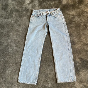 Weekday Arrow Low Straight Jeans ljusblå - Säljer ett par ljusblå Arrow Low Straight Jeans från Weekday. Klassisk femficksmodell med låg midja och raka ben. Jeansen är i bomull och har en snygg, avslappnad passform. Perfekta för dig som gillar en enkel och clean look.