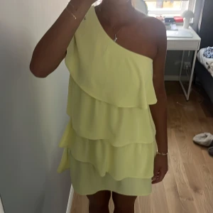 Gul one shoulder klänning från Zara - Supersöt ljusgul kortklänning från Zara med volanger i flera lager och one shoulder-design. Mycket bra skick. Storlek M men passar också S. Pris kan diskuteras och kom privat för fler bilder.