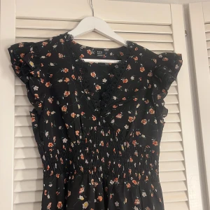 Svart blommig klänning  - Jättefin svart blommig klänning storlek L 