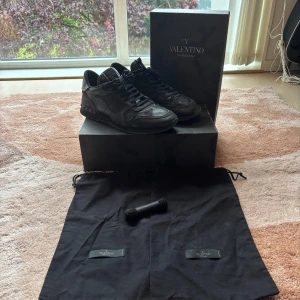 Valentino rockrunners  - Svarta Valentino Garavani Rockrunner sneakers med diskret camouflage-mönster. Skorna har snörning, rund tå och platt sula. Materialmix av skinn och textil ger en lyxig känsla. Kommer med originalkartong, dustbags och extra skosnören. Hör av dig om fårgor🔥🔥