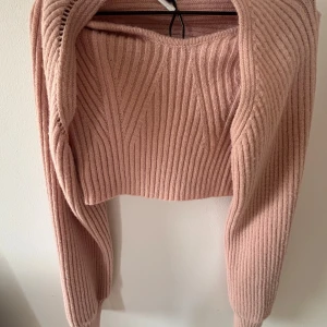 Rosa stickad bolerotopp från Shein - Supersöt ljusrosa stickad bolerotopp från Shein. Toppen är croppad och ribbstickad med långärmad bolero-del och en ärmlös tubtopp under. Använd max 3 gånger. Annonsen finns på flera ställen så skriv till mig innan ni trycker på köp🫶🏻