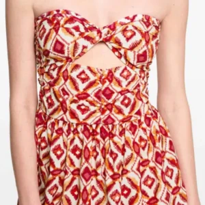 Mönstrad kortklänning från Mango - Superfin kortklänning från Mango med färgstarkt mönster i rött, orange och vitt. Klänningen är axelbandslös med twistad byst och cut-out framtill. Luftig modell i bomull, perfekt för varma dagar. Snygg och unik look som sticker ut!